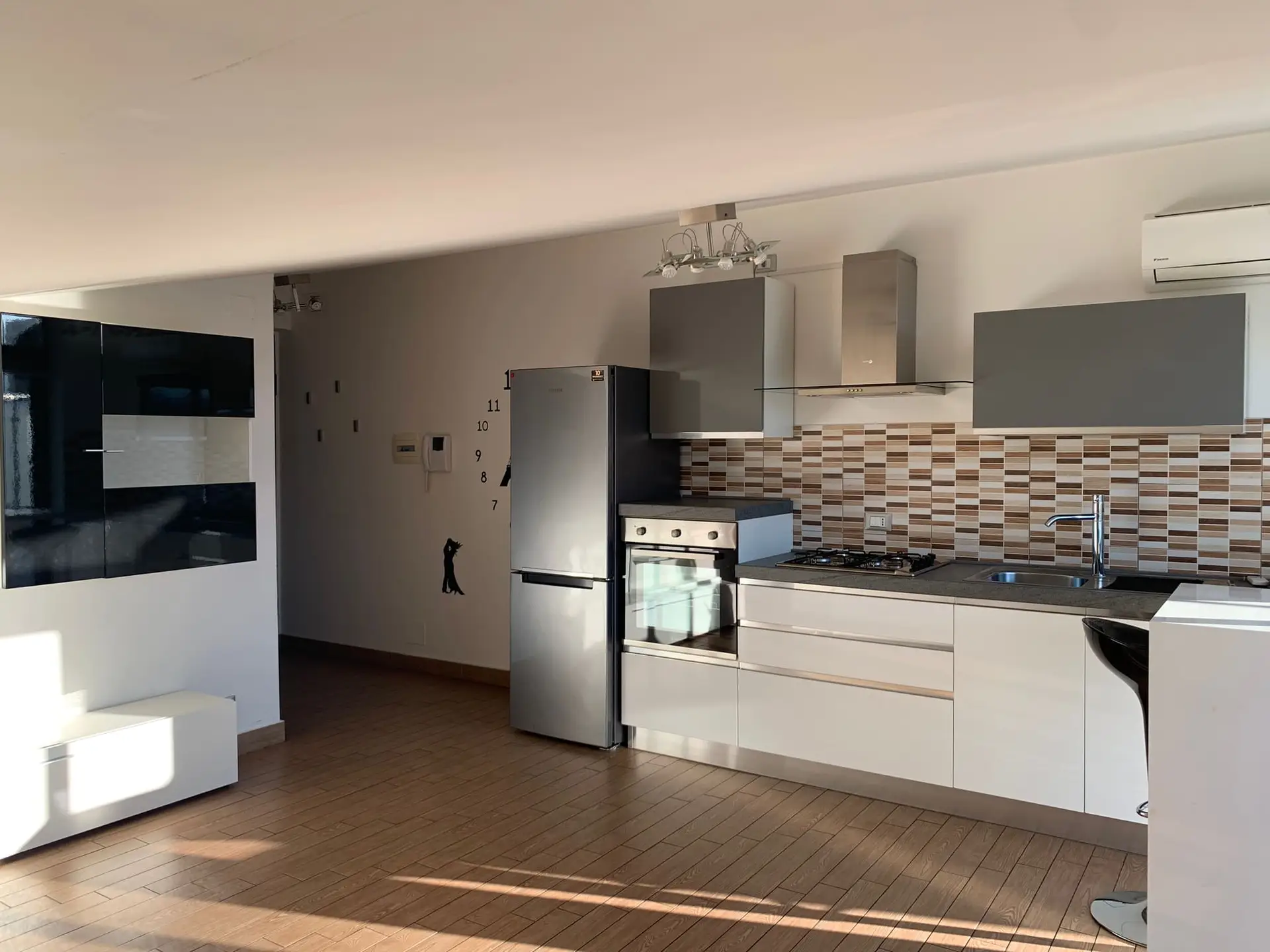 Cucina a vista con penisola e soggiorno in mansarda – Livoti Group